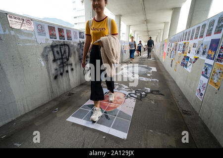 Kowloon Tong, Hong Kong. Il 23 settembre 2019. Donna cammina oltre il ritratto di Mao Zedong sulla passerella pedonale a Kowloon Tong. La settimana prima il settantesimo anniversario della fondazione della Repubblica popolare cinese il 1 ottobre molti cosiddetti Lennon pareti sono apparsi in tutta la città e sono coperte pro-democrazia posters e graffiti. Iain Masterton/Alamy Live News. Foto Stock