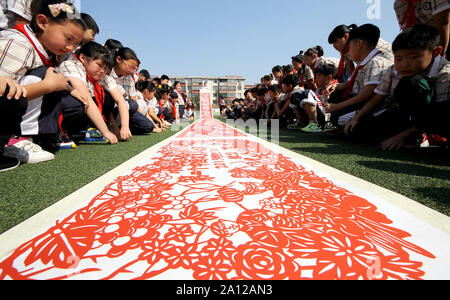 (190923) -- ZAOZHUANG, Sett. 23, 2019 (Xinhua) -- Alunni visualizzare una raccolta di carta a tema di taglio opera d'arte a Jianshelu scuola primaria nella città di Zaozhuang, est della Cina di Provincia di Shandong, Sett. 23, 2019. Agli agricoltori di tutto il paese celebrare i coltivatori cinesi' harvest festival, che cade sul Autumn Equinox, o sett. 23 Quest'anno. (Foto di Sun Zhongzhe/Xinhua) Foto Stock