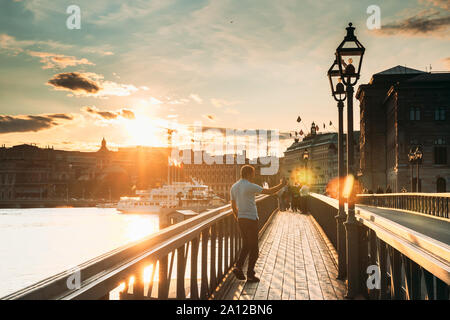 Stoccolma, Svezia - 27 Giugno 2019: uomo viaggiatore turistica prendendo immagini foto vicino alla celebre Skeppsholmsbron - Skeppsholm Bridge. Un luogo popolare e dest Foto Stock