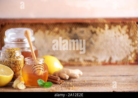 Ingredienti per una sana bevanda calda. Limone, zenzero, menta, miele, apple e spezie su sfondo di legno. Copia dello spazio. Medicina alternativa concetto. Pulire Foto Stock