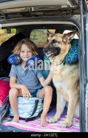5 anno vecchio ragazzo con il suo Pastore Tedesco cane, nel retro di un SUV Foto Stock