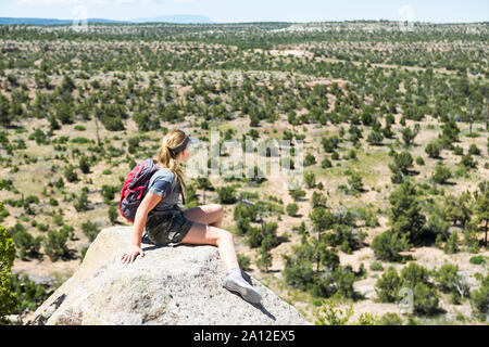 Vista posteriore di 13 anno vecchia ragazza escursionista affacciato sul deserto vista, Tsankawi rovine, NM Foto Stock