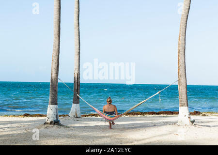 Donna di riposo in amaca prendendo foto con smart phone, Grand Cayman Island Foto Stock