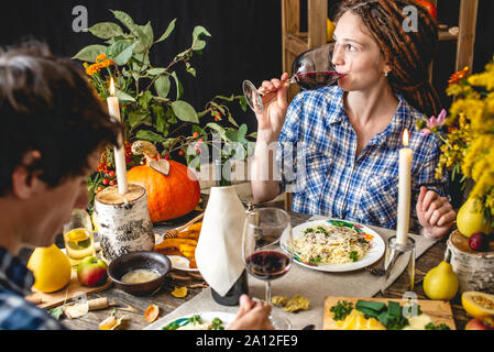 Data del fine settimana con vino rosso e pasta. Carino a cena con i fiori per una coppia in amore in uno stile rustico. Concetto rapporto romantico in autunno atmosph Foto Stock