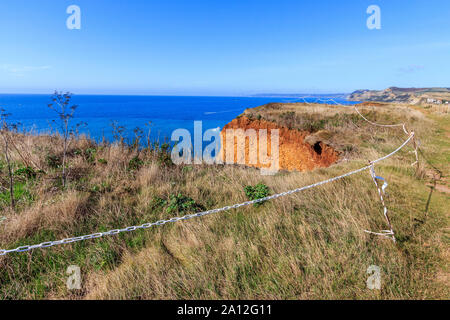 Cliff cade spazio cintato pericolo, West Bay resort costa, Jurassic Coast, sbriciolare scogliere di arenaria,sito UNESCO, Dorset, England, Regno Unito, GB Foto Stock