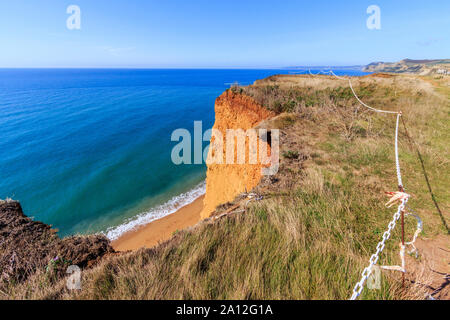 Cliff cade spazio cintato pericolo, West Bay resort costa, Jurassic Coast, sbriciolare scogliere di arenaria,sito UNESCO, Dorset, England, Regno Unito, GB Foto Stock