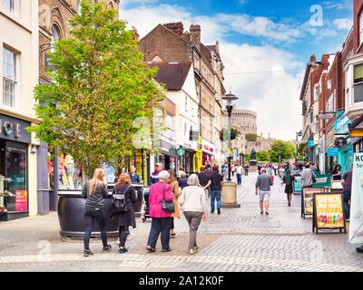 5 Giugno 2019: Windsor, Berkshire, Regno Unito - acquirenti e turisti in Peascod Street, la principale strada commerciale della città con il Castello di Windsor in alto... Foto Stock