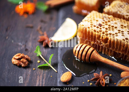 Autunno picnic. Il tè alle erbe, miele e prodotti di apicoltura, Apple, limone, calendula, spezie su sfondo scuro. Sistema immunitario supporto con la medicina alternativa Foto Stock