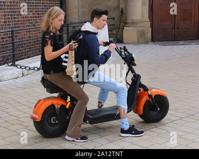 Cracovia. Cracovia. Polonia. Giovane coppia in bicicletta elettrica a noleggio nel centro storico Foto Stock