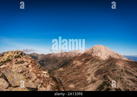 Vihren e Kutelo picchi con il cavallo attraversare nel parco nazionale di Pirin, Bulgaria. Vista panoramica dal Muratov picco. Foto Stock