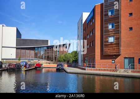 Narrowboats ormeggiata in Aylesbury bacino con Travelodge e il teatro in background Foto Stock