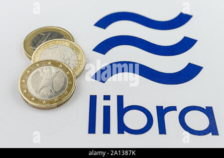 Facebook Libra cryptocurrency logo stampato e le monete in euro al loro fianco. Close up foto con profondità di campo ridotta. Foto Stock