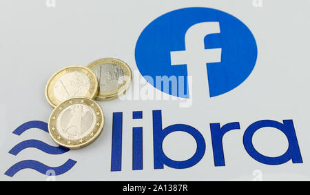 Facebook Libra cryptocurrency logo stampato e le monete in euro al loro fianco. Close up foto con profondità di campo ridotta. Foto Stock