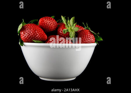 Bianco di ceramica ciotola di fragole fresche isolato su nero Foto Stock