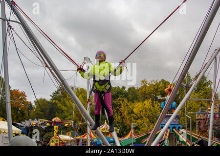 Ragazzina salta su un trampolino con una fascia elastica Foto Stock