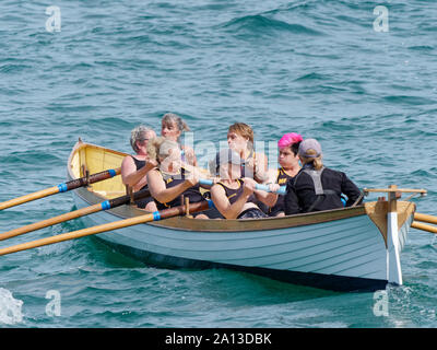 Le donne canottaggio in squadre di sei nei tradizionali costruiti a mano gig pilota barche. l annuale west country evento richiama squadre provenienti da Europa (London Cornish) Foto Stock