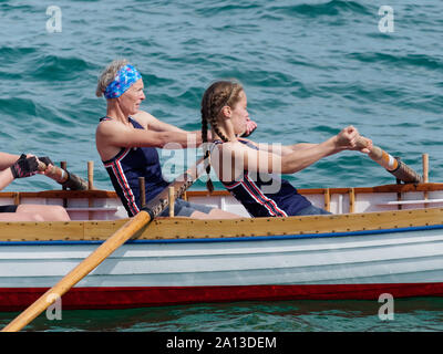 Le donne canottaggio in squadre di sei nei tradizionali costruiti a mano gig pilota barche. l annuale west country evento richiama squadre provenienti da Europa (London Cornish) Foto Stock