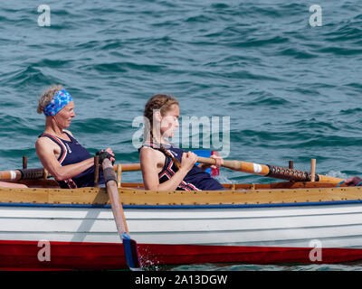 Le donne canottaggio in squadre di sei nei tradizionali costruiti a mano gig pilota barche. l annuale west country evento richiama squadre provenienti da Europa (London Cornish) Foto Stock