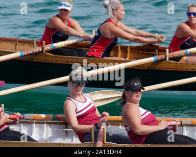 Le donne canottaggio in squadre di sei nei tradizionali costruiti a mano gig pilota barche. l annuale west country evento richiama squadre provenienti da Europa (London Cornish) Foto Stock