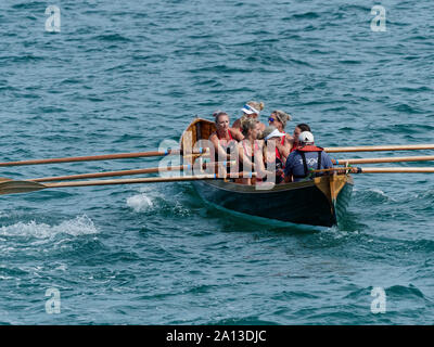 Le donne canottaggio in squadre di sei nei tradizionali costruiti a mano gig pilota barche. l annuale west country evento richiama squadre provenienti da Europa (London Cornish) Foto Stock