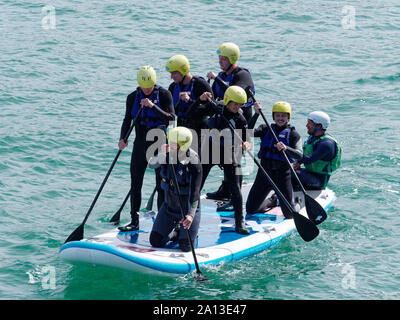 Le donne canottaggio in squadre di sei nei tradizionali costruiti a mano gig pilota barche. l annuale west country evento richiama squadre provenienti da Europa (London Cornish) Foto Stock