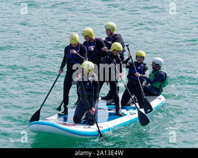 Le donne canottaggio in squadre di sei nei tradizionali costruiti a mano gig pilota barche. l annuale west country evento richiama squadre provenienti da Europa (London Cornish) Foto Stock