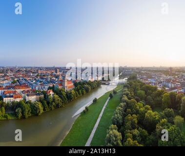 Vista della città, Maximilianskirche in Isarvorstadt e Reichenbachbrucke oltre Isar all'alba, le aree verdi e il quartiere di Au sulla destra, antenna Foto Stock