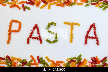 Fusilli pasta multicolore su uno sfondo bianco, scritte pasta formata da materie pasta, orientamento orizzontale Foto Stock