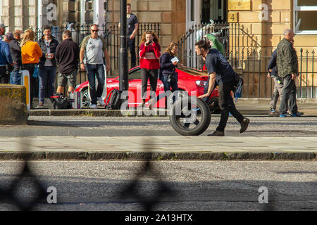 Un membro di equipaggio rotoli di una ruota di scorta lungo la strada durante le riprese. Fast & Furious 9 ha avvolto la produzione in Edinburgh, dopo diverse settimane di riprese per il film più recente in alto numero di ottani car chase franchising. Le ultime scene sono state riprese oggi su Melville Street, una graziosa terrazza georgiana nella capitale del West End. Stunt Driver, in piedi per le stelle come Vin Diesel, hanno guidato le loro muscolo automobili su e giù per la strada, a fianco di veicoli della fotocamera. Fast & Furious 9 è dovuto per il rilascio il 22 maggio 2020. Foto Stock