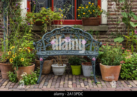 Romantico rose bancone di una bella casa con un sacco di vasi di piante e fiori attorno ad essa facendo una bella scena romantica Foto Stock