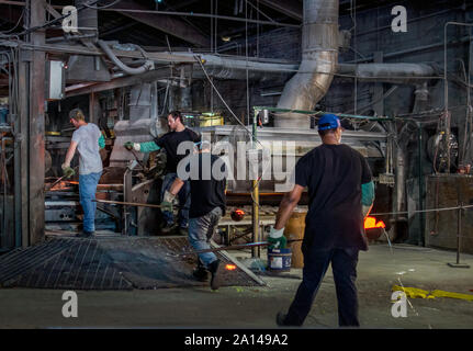 27 sett 2019 Kokomo Indiana America; lavoratori portano il vetro fuso su una macchina che con l aiuto di un artista, viene quindi utilizzato per produrre fogli di colorate Foto Stock
