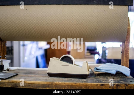 Un rotolo di marrone carta craft e un rotolo di nastro è impostato per avvolgere il fragile vetro in un vetro Arte shop Foto Stock