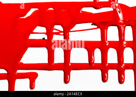 Flussi di rosso vernice spessa su sfondo bianco Foto Stock