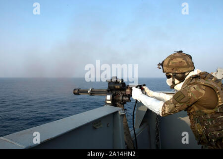 Un Royal Marine spara un MC-44 Minigun a bordo della British Royal Fleet nave ausiliaria Cardigan Bay. Foto Stock