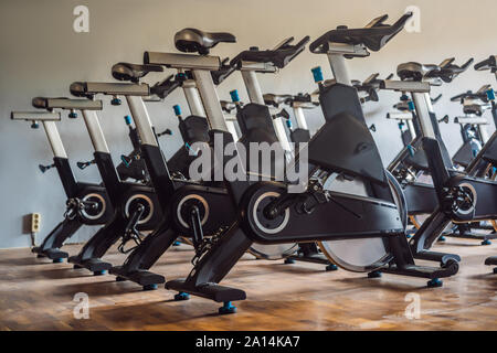 Aerobica spinning cyclette palestra con molti in una riga Foto Stock