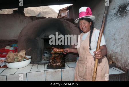 Cuzco, Perù - Agosto 13 2011: Un peruviano cook e il forno. Mostra un arrosto di cuis. Foto Stock