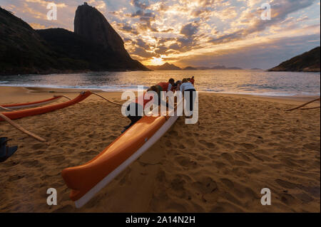 Rio de Janeiro, Brasile - 17 agosto 2013: un gruppo di donne la preparazione di canoe outrigger per andare al mare. Foto scattata a Red Beach, accanto al sugarloaf m Foto Stock