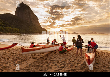 Rio de Janeiro, Brasile - 17 agosto 2013: un gruppo di donne la preparazione di canoe outrigger per andare al mare. Foto scattata a Red Beach, accanto al sugarloaf m Foto Stock