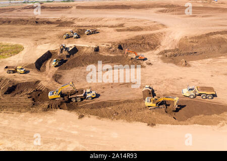 Escavatori che caricano il terreno su un trasportatore articolato Trucks, immagine aerea. Foto Stock