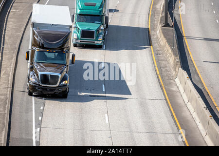 Big Rig marrone classico e cofano verde semi camion adibiti al trasporto commerciale industriale cargo in dry van semirimorchi guida su strada la fusione di linee su Foto Stock