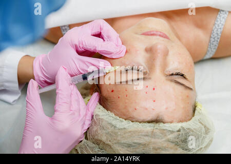 Estetista facendo iniezione del viso per donna. Anti-invecchiamento della rivitalizzazione cosmetologia procedura Foto Stock