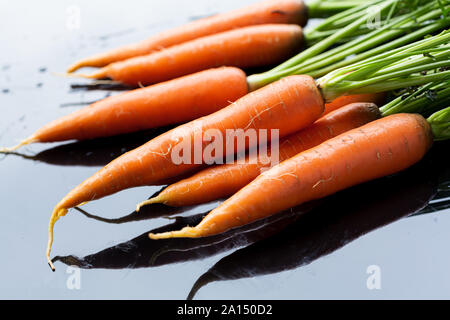 Freschi carote organico sulla superficie nera Foto Stock