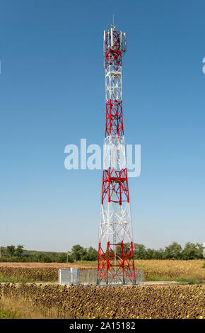 5G antenna per la connessione internet ad alta velocità di distribuzione. 5G di ripetitori fuori città. Colori luminosi rosso e bianco. Foto Stock