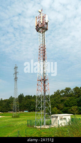 5G antenna per la connessione internet ad alta velocità di distribuzione. 5G di ripetitori fuori città. Colori luminosi rosso e bianco. Foto Stock