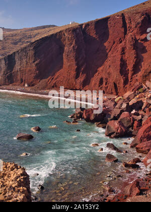 Insolito rosso brillante montagne sotto il cielo blu e acque turchesi su Kokkini Red Beach Santorini Grecia Foto Stock