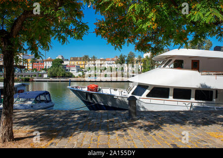 Tour barche ormeggiate lungo il fiume Guadalquivir con vedute di case e appartamenti nel Barrio Triana quartiere di Siviglia - Siviglia - Andalusia, Spai Foto Stock