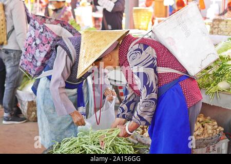 Le etnie locali di persone a vendere e acquistare prodotti a venerdì il mercato delle pulci in Shaxi villaggio delle antiche tè e cavallo rotta commerciale in Yunnan in Cina. Foto Stock