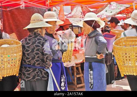 Le etnie locali di persone a vendere e acquistare prodotti a venerdì il mercato delle pulci in Shaxi villaggio delle antiche tè e cavallo rotta commerciale in Yunnan in Cina. Foto Stock