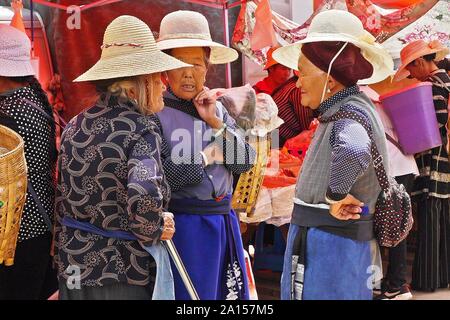 Le etnie locali di persone a vendere e acquistare prodotti a venerdì il mercato delle pulci in Shaxi villaggio delle antiche tè e cavallo rotta commerciale in Yunnan in Cina. Foto Stock