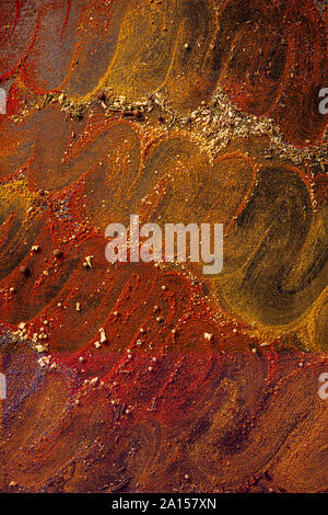 Sfondo speziato con assortimento di spezie differenti su sfondo scuro. Foto Stock